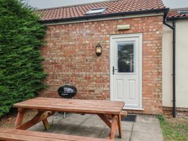 An outdoor area with a table and grill at Puffin in Flamborough