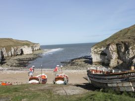 A beach with fishing boats and cliffs by the sea at Kittiwake in Flamborough