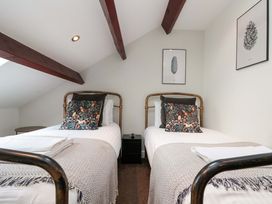 A bedroom with two single beds and artwork at Kittiwake in Flamborough