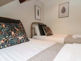 A bedroom with two beds and wall art at Kittiwake in Flamborough