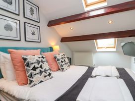 A bedroom with a double bed and wall art at Kittiwake in Flamborough