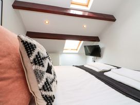 A bedroom with a bed and television at Kittiwake in Flamborough