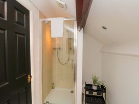A bathroom with a shower and a black door at Kittiwake Flamborough