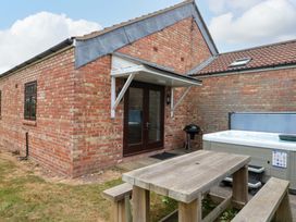 An outdoor area with a hot tub and table at Kittiwake in Flamborough