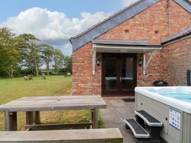 An outdoor area with a hot tub and picnic table at Kittiwake in Flamborough