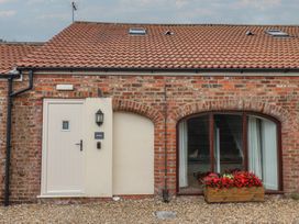 An outdoor view of a brick building with a door and window at Kittiwake Flamborough