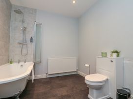 A bathroom with a bathtub, shower, toilet, and radiator at The Pheasantry in Flamborough