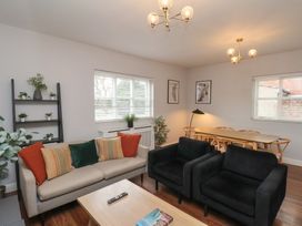 A living room with a sofa, armchairs and dining area at The Pheasantry in Flamborough
