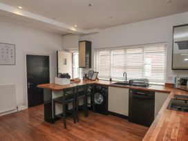 A kitchen with appliances and bar stools at The Pheasantry in Flamborough