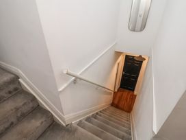 A staircase with a handrail and door at The Pheasantry in Flamborough