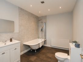 A bathroom with a bathtub, sink, toilet and shower at The Pheasantry in Flamborough