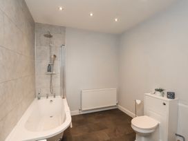A bathroom with a bathtub, toilet, and shower at The Pheasantry in Flamborough