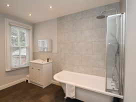 A bathroom featuring a bathtub, shower, sink, and window at The Pheasantry in Flamborough