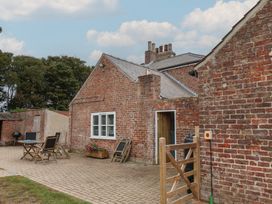 An outdoor area with brick walls and furniture at The Pheasantry in Flamborough