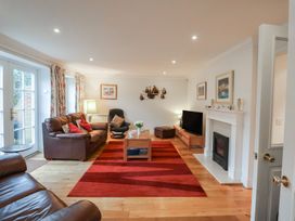 A living room with a sofa, table, and television at 9 Church Farm Rise, Aldeburgh