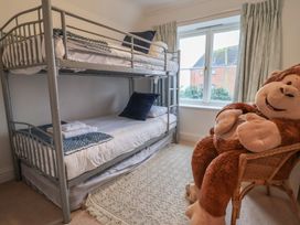 A bedroom with a bunk bed and a teddy bear at 9 Church Farm Rise Aldeburgh