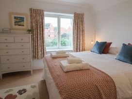 A bedroom with a bed and a dresser at 9 Church Farm Rise in Aldeburgh