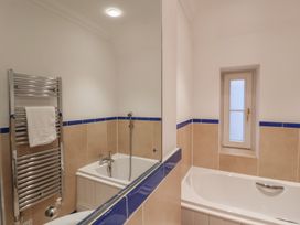 A bathroom with a bathtub and towel radiator at 9 Church Farm Rise Aldeburgh