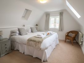 A bedroom with a bed and a chair at 9 Church Farm Rise in Aldeburgh