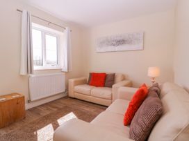 A living room with a sofa and a lamp at Country Cottage in Brecon