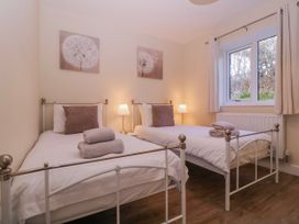 A bedroom with two single beds and wall art at Country Cottage in Brecon