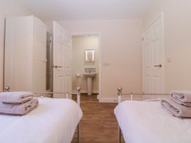 A bedroom with two beds and a bathroom at Country Cottage Brecon