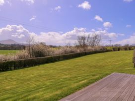 A view of a grassy field with trees and power lines at Country Cottage in Brecon
