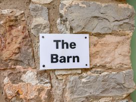 A sign with the name The Barn on a stone wall at The Barn Tafarn-Y-Gelyn