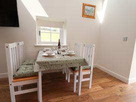 A dining room with a table and chairs at The Barn in Tafarn-Y-Gelyn