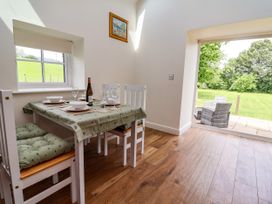 A dining room with a table and chairs at The Barn in Tafarn-Y-Gelyn