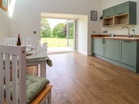 A dining room with a table and chairs at The Barn in Tafarn-Y-Gelyn