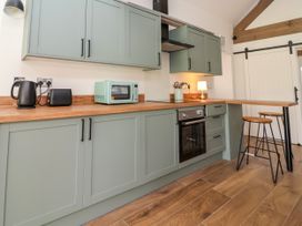 A kitchen with appliances and seating at The Barn Tafarn-Y-Gelyn