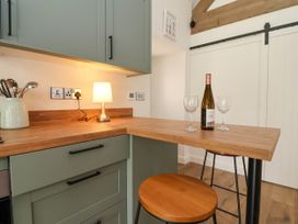 A kitchen with a bar area and wine bottle at The Barn in Tafarn-Y-Gelyn