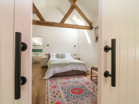 A bedroom with a bed and bedside table at The Barn in Tafarn-Y-Gelyn