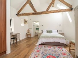 A bedroom with a bed and desk at The Barn in Tafarn-Y-Gelyn
