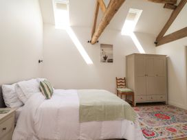 A bedroom with a bed and wardrobe at The Barn Tafarn-Y-Gelyn