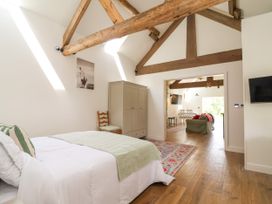 A bedroom with a bed and wardrobe at The Barn in Tafarn-Y-Gelyn
