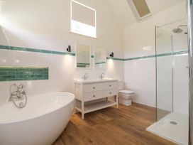 A bathroom with a bathtub and sink at The Barn Tafarn-Y-Gelyn