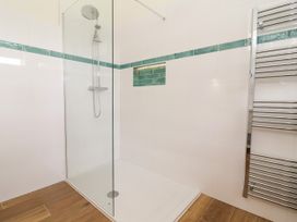 A shower with glass screen and heated towel rail at The Barn Tafarn-Y-Gelyn