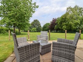 An outdoor area with chairs and a table at The Barn in Tafarn-Y-Gelyn