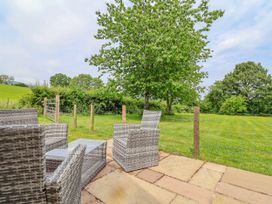 An outdoor seating area with chairs and a table at The Barn Tafarn-Y-Gelyn