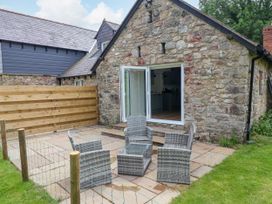 An outdoor seating area with chairs and table at The Barn in Tafarn-Y-Gelyn