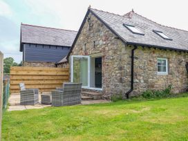 An outdoor area with two chairs and a table at The Barn in Tafarn-Y-Gelyn
