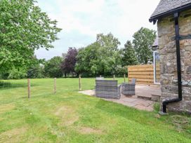 An outdoor garden with chairs and fence at The Barn Tafarn-Y-Gelyn