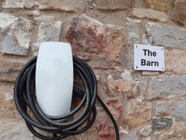 A Tesla charger mounted on a stone wall at The Barn in Tafarn-Y-Gelyn
