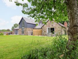 A house with stone exterior and large windows at The Barn in Tafarn-Y-Gelyn