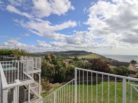 A view from a deck overlooking hills and the ocean at 13 Downside Close Charmouth