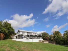 A house with a balcony on a hillside at 13 Downside Close in Charmouth