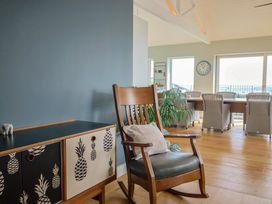 A dining room with a rocking chair and dining table at 13 Downside Close in Charmouth