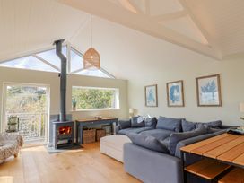 A living room with a fireplace and windows at 13 Downside Close in Charmouth